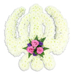 A carefully handcrafted Sikh Khanda floral tribute is set against a spotless white background, its distinctive religious emblem formed entirely from densely packed white chrysanthemums. The symbolic elements of the Khanda are clearly defined in petals: a central double-edged sword rising upright, encircled by the unbroken ring of the chakkar, and framed by two curved kirpans that sweep outward and cross elegantly at the base. Each petal contributes to a soft, cushion-like surface of creamy white, with subtle shadows and highlights giving the whole arrangement depth and a gentle sense of movement. The flowers appear freshly arranged, their feathery heads tightly clustered so no gaps or stems are visible, creating a feeling of purity and serenity. At the lower centre, where the kirpans meet, a small but eye-catching accent bouquet adds warmth and colour. Three pink roses, lush and full, form the heart of this cluster, surrounded by smaller deep purple blooms that lend a more reflective tone. Wisps of dark green fern and foliage peek through, adding texture and a reminder of living gardens like those around Hither Green station and the nearby parks. A faint shadow beneath the tribute suggests its three-dimensional structure, as though it has just been placed for a Sikh funeral or memorial ceremony. The overall effect is of a lovingly made, meaningful tribute, reflecting both strong Sikh faith and the gentle compassion of family and friends gathering in Hither Green to say a respectful goodbye.
